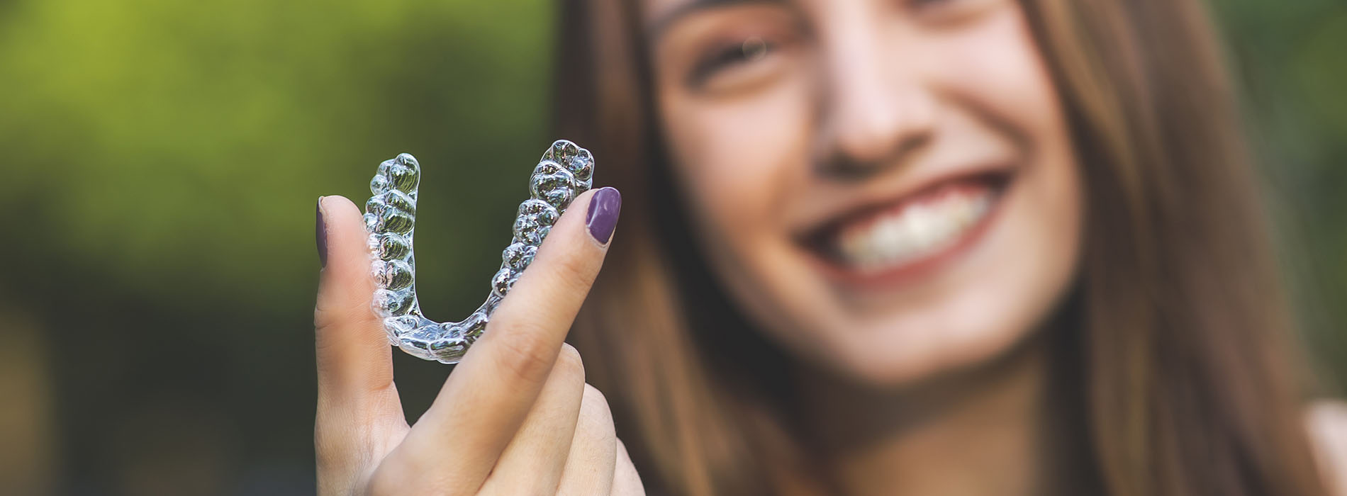 The image shows a person holding a plastic letter V with their hand.